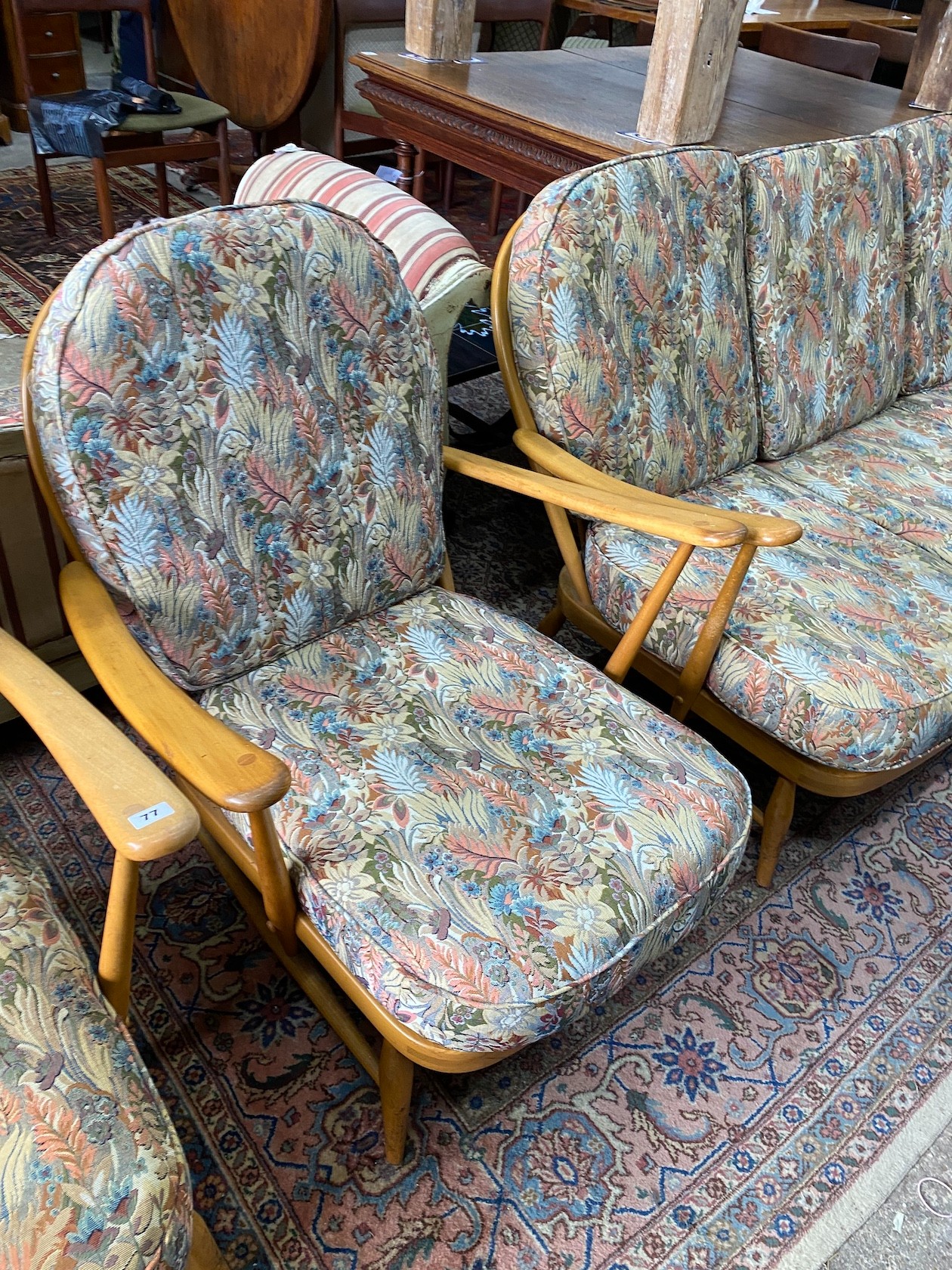 An Ercol beech three piece lounge suite and footstool, settee length 174cm, width 80cm, height 82cm